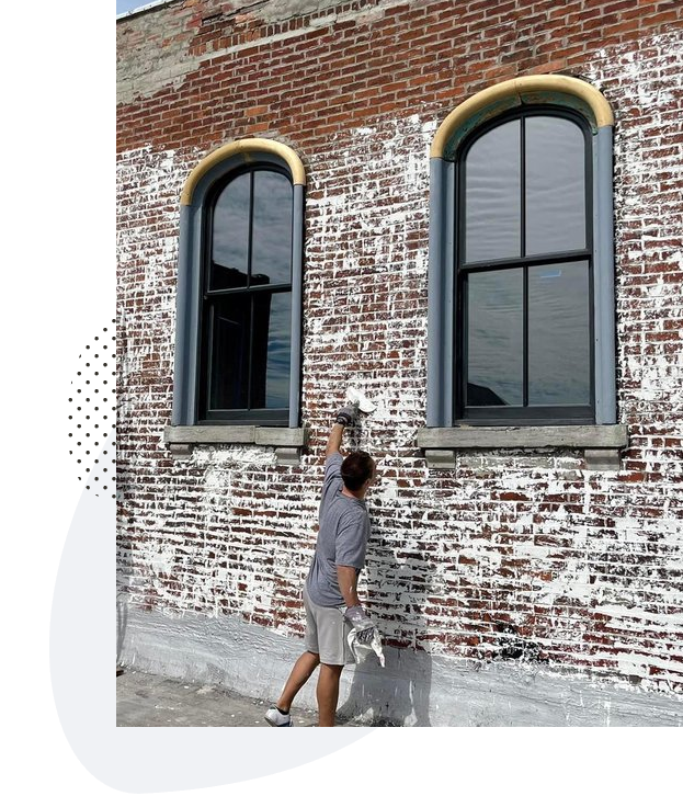 Mortar wash being applied by hand to red brick on an Austin building