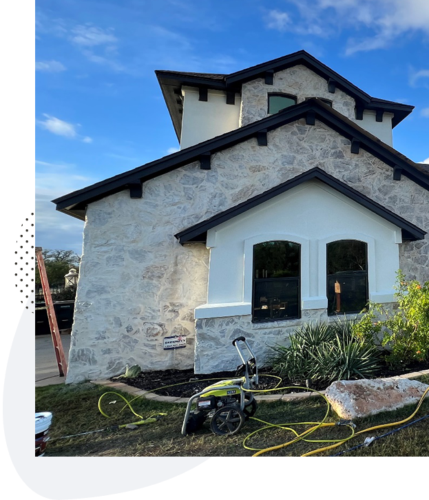 Light mortar wash on the stone exterior of an Austin home, pressure washer still on the lawn