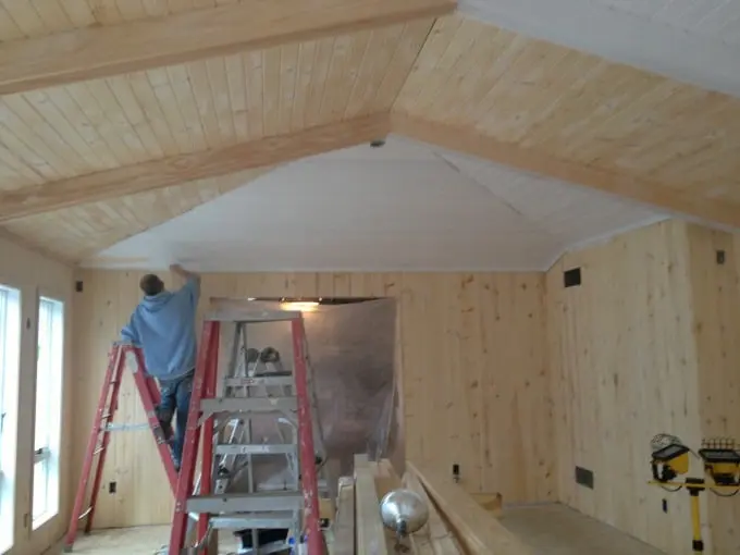 Primer and paint on ceiling beams in an Austin home