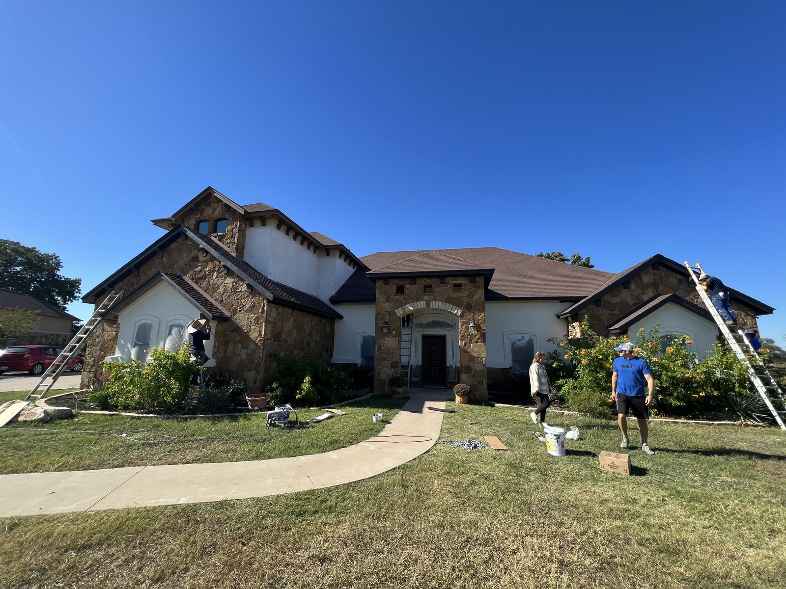 Crew limewashing a stone ranch home in Austin