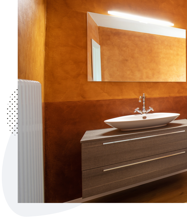 Burnished Venetian plaster in a warm ochre finish above an Austin bathroom vanity
